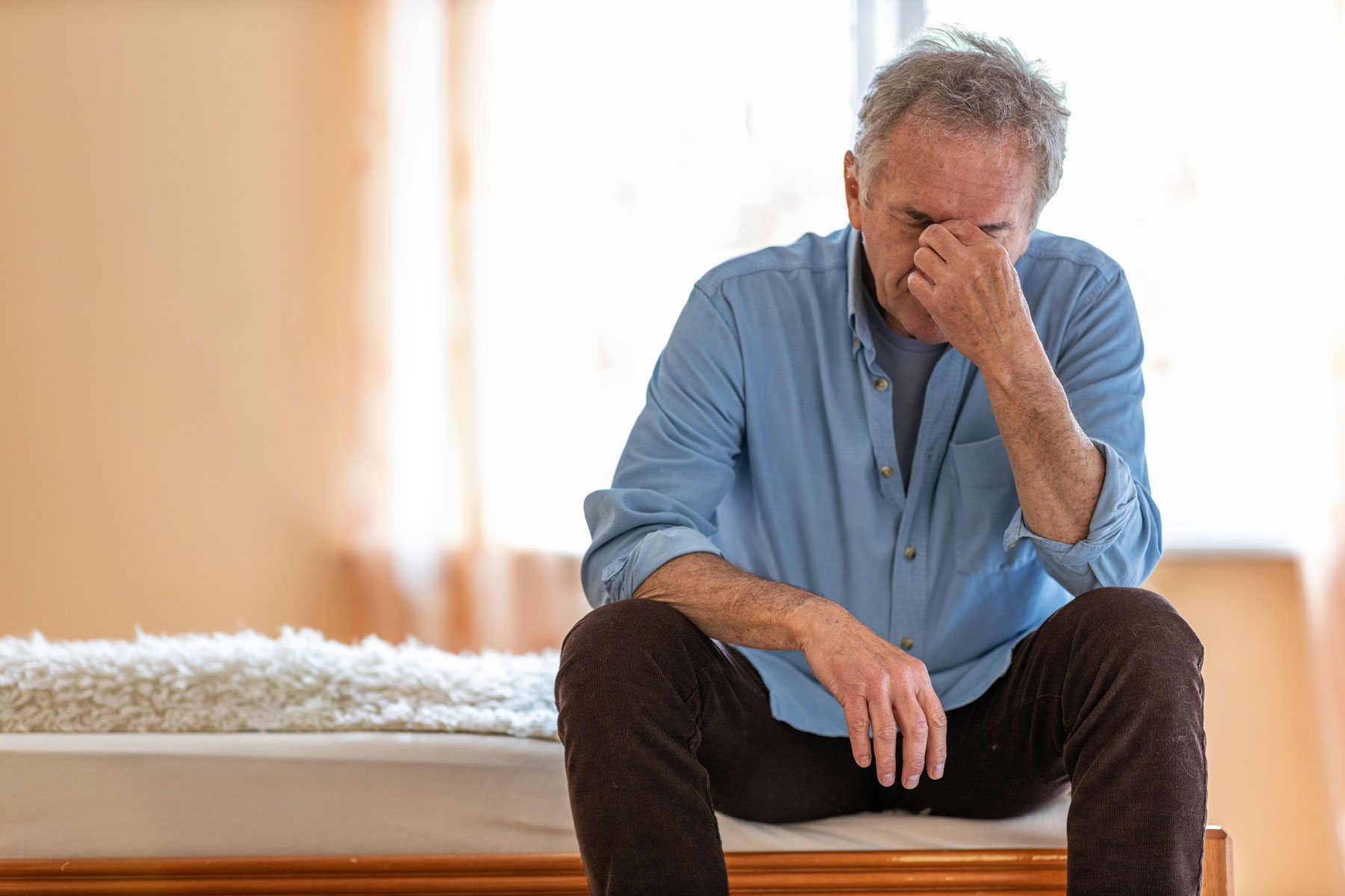 How To Manage Anxiety in Seniors a senior man struggles to cope with his anxiety