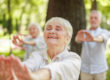 seniors practice tai chi outside on a nice day