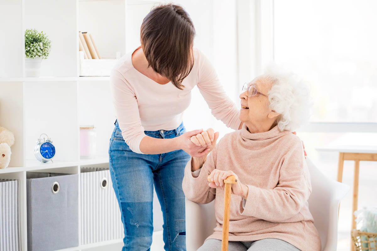 Woman helping lovely old lady an adult daughter helps her senior mother with the transition to assisted living