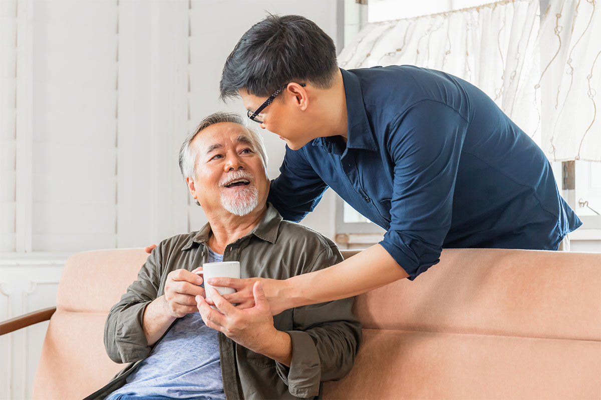 What Is Respite Care A Guide for Michigan Caregivers Image 1 Son caretaker giving elderly father coffee